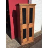 A Victorian mahogany cupboard with moulded cornice above glazed panelled doors enclosing an interior