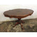 An oval scalloped top mahogany centre table, the frieze with two drawers, supported on a fluted