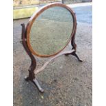 An oval mahogany dressing table mirror with boxwood strung frame on shaped supports with splayed