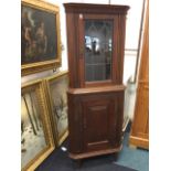 A mahogany corner cupboard with moulded dentil cornice above leaded glass door and a fielded