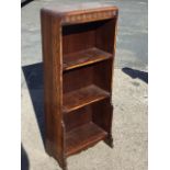 An oak open bookcase with caddy moulded top above press moulded frieze, with three open shelves