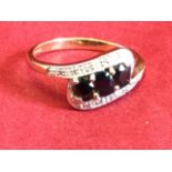 A 9ct white gold sapphire & diamond ring, the three oval sapphires framed by scrolled bands of