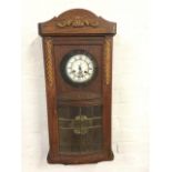 A European oak wallclock, the arched cornice with applied scroll carving above a bowfronted door