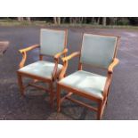A pair of mahogany armchairs, the backs with upholstered panels in rectangular reeded frames, with