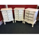 A set of three painted serpentine fronted cabinets, each with four drawers having applied swagged