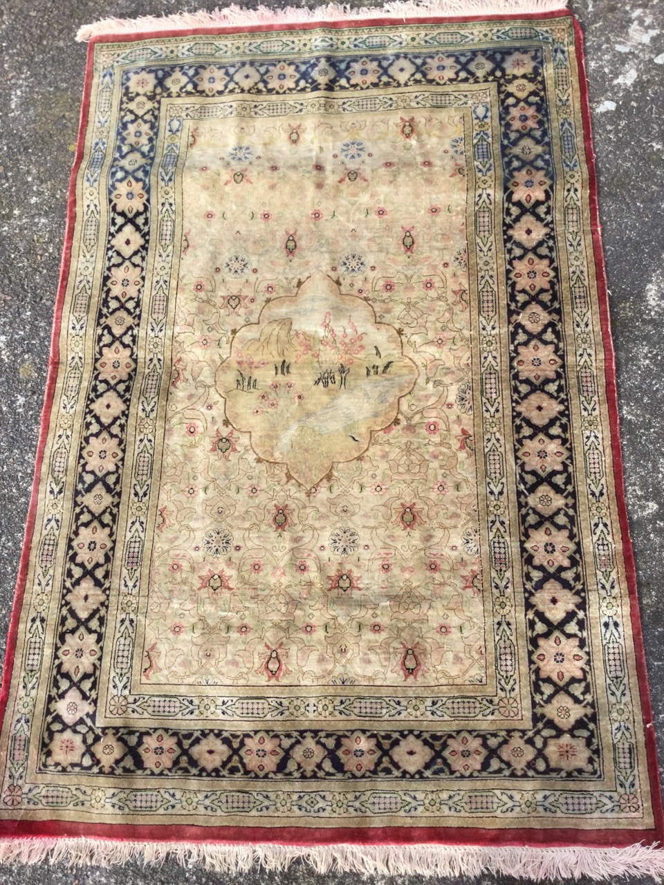 A fine silk rug woven with central scalloped landscape medallion on rectangular floral field, within