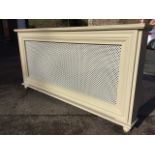 A painted rectangular radiator cover, the shelf above a moulded frame enclosing a grill panel,