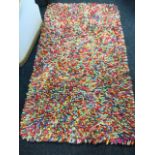 A contemporary hookie style multicoloured rug. (61in x 34in)