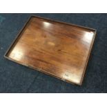 A rectangular Victorian mahogany tray inlaid with oval shell paterae, having brass corner mounts and