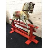 A C20th carved wood rocking horse with later bridle, having dappled gesso body with horsehair mane &
