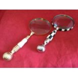 A Victorian style brass table magnifying glass with circular lens on ribbed brass handle, set with