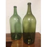 Two early nineteenth century olive glass hand blown wine bottles with moulded lips and tapering