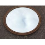 A circular mahogany mirror with bevelled plate in moulded frame. (24in)