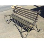 An Edwardian 6ft wrought iron garden bench with scrolled frame, having slatted back & seat. (72in)