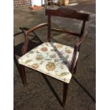 A nineteenth century mahogany elbow chair, with ribbed carved back rail and panelled arms above an