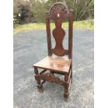 A nineteenth century carved oak side chair, the back with arched scroll carved rail above a vase