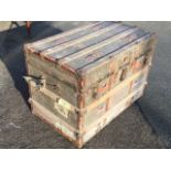 A rectangular Edwardian cabin trunk, the canvas covered case with hardwood slats and iron mounts,