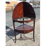 A Georgian mahogany bowfronted corner washstand, the hinged top revealing a platform cut for bowls