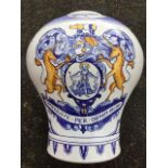 A large handpainted delft baluster vase decorated with armorials and chinoiserie figures and foilage