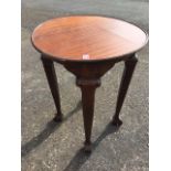 A circular Edwardian mahogany lamp table, the tray top on square tapering scroll carved legs with