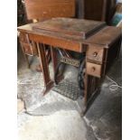 A Singer sewing machine in oak table having moulded hinged top to compartment, above a frieze with