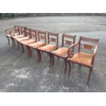 A set of eight regency style mahogany dining chairs, the backs inlaid with scrolled brass decoration