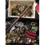 A Seaforth Highlanders tapering swagger stick with brass mounts; and a collection of military badges