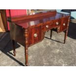 A George IV mahogany sideboard with platform step to rectangular top having rounded corners