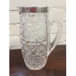 A cut glass lemonade jug with hallmarked silver mounts, the tall tapering glass cut with star panels