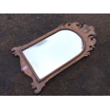 An eighteenth century style walnut mirror, the arched plate in cushion moulded frame with scroll