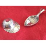 A Sterling silver caddy spoon modelled as a ribbed jockeys cap with vacant shield to peak - Sterling