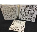 A pair of square decorative wall pieces with pierced foliate scrolled fretwork cut panels in moulded