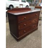 A Victorian mahogany chest of drawers with shaped upstand and rounded corners, having three long