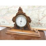A Victorian carved oak mantleshelf barometer, the circular dial with crescent shaped thermometer
