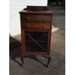 An Edwardian mahogany music cabinet with shaped upstand to moulded top above two drop-down drawers