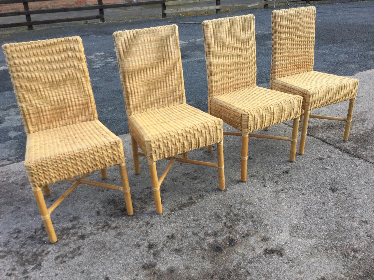 A set of four cane dining chairs with rectangular woven backs above box seats, raised on turned legs