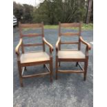 A pair of large Victorian country elm armchairs, the ladderbacks with scrolled arms above solid