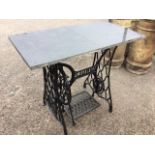 A Victorian cast iron sewing machine table with pierced Singer treadle mechanism on casters, mounted