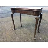 A Georgian mahogany turn-over-top tea table with rounded projecting corners above a plain frieze,