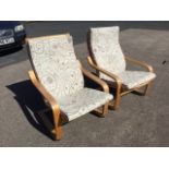 A pair of contemporary rocking chairs with loose cushions and platform arms on sprung wood