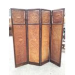 An Edwardian four-fold oak screen, the two-way brass hinged folds having embossed leather panels