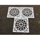 A set of three square decorative panels cut with pierced fretwork centering on hearts, in plain