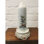 A Chinese porcelain pillar stand with floral enamelled decoration, the column on saucer base with