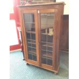 An Edwardian mahogany bookcase, the rectangular moulded top with upstand above a pair of leaded