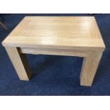 A contemporary heavy oak coffee table, the panelled top on square column legs. (24in x 16.5in x