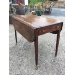 A Georgian mahogany pembroke table, the top with two rounded rule-jointed drop leaves above an ebony