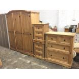 A pine bedroom suite with three door wardrobe, a pair of bedside cabinets each with three panelled