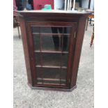 A Victorian mahogany corner cabinet with moulded ogee cornice above an astragal glazed door
