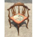 An Edwardian mahogany corner chair, the boxwood strung back with vase shaped splats above a