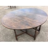 An oval nineteenth century oak dining table, with two drop leaves raised on baluster turned legs
